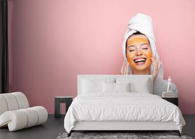 happy girl with citrus facial mask touching face with closed eyes isolated on pink Wall mural