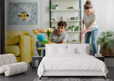 happy man and woman doing spring cleaning in apartment Wall mural