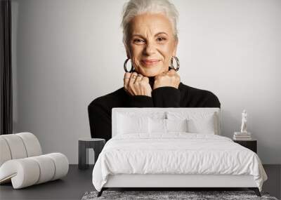 happy middle aged business woman in elegant smart casual attire posing on grey background Wall mural