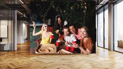 Happy multiethnic friends with beer, pizza and popcorn having fun during summer party Wall mural