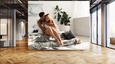 happy tender man hugging woman in bed in the morning Wall mural