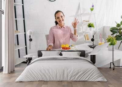 happy woman showing ok sign near tasty vegetables Wall mural