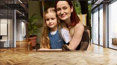 happy woman with adorable daughter looking at camera near modern trailer home, smiling faces Wall mural