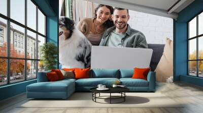 happy young couple watching movie on laptop near australian shepherd dog, banner. Wall mural