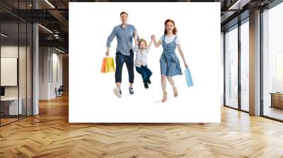 Happy young family with one child holding shopping bags and smiling at camera isolated on white Wall mural