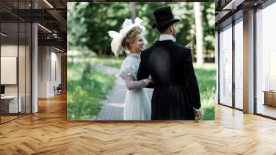 happy young victorian woman standing with man in hat outside Wall mural