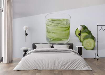 high angle view of glass with fresh drink and sliced cucumbers isolated on grey Wall mural