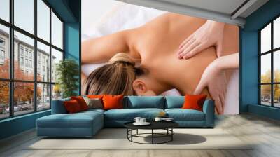 High angle view of masseur massaging back of woman on massage table Wall mural