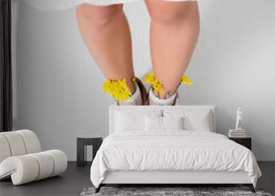 high angle view of model in sneakers with yellow spring wildflowers posing on white Wall mural