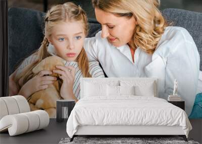 high angle view of mother and daughter sitting on couch together and chatting Wall mural