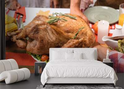 Horizontal image of african american woman putting turkey on table near family during thanksgiving dinner Wall mural