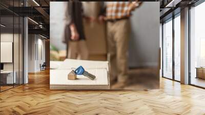 keys lying on cardboard box on foreground and blurred view of senior couple, moving concept Wall mural