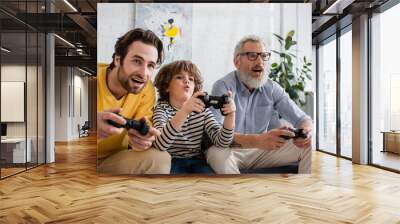 KYIV, UKRAINE - APRIL 12, 2021: Kid playing video game with parent and grandparent Wall mural