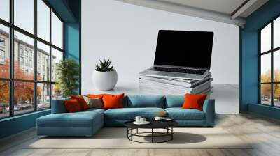 laptop on stack of journals, and flowerpot isolated on grey Wall mural