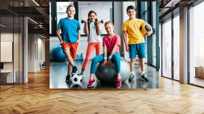 Laughing preteen kids posing with sport equipment Wall mural