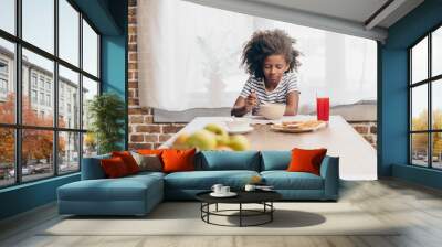 Little girl eating breakfast Wall mural