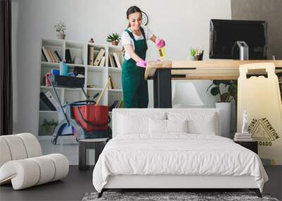 Low angle view of smiling young janitor cleaning modern office Wall mural