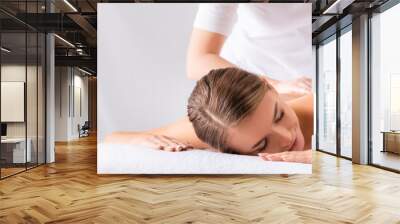 masseur massaging pleased young woman on massage table in spa salon, banner Wall mural