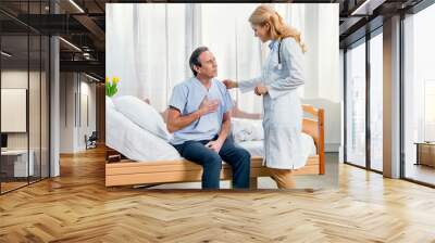 middle aged man with chest pain and doctor standing near him in hospital Wall mural