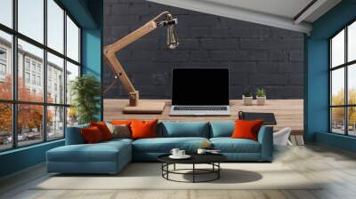 modern workplace with laptop with blank screen, plants, lamp and notebook on wooden table Wall mural