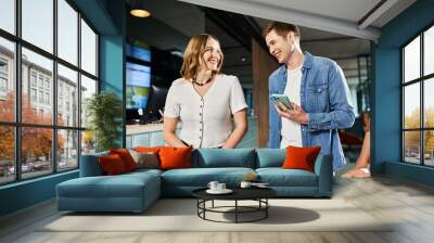 Multicultural colleagues in casual attire gathered and conversing in a hotel lobby during a corporate trip. Wall mural