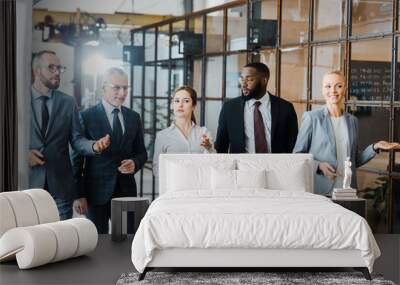 multicultural group of handsome businessmen and happy businesswomen walking in office Wall mural