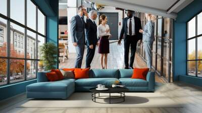 multicultural handsome businessmen and attractive businesswomen standing and talking in office Wall mural