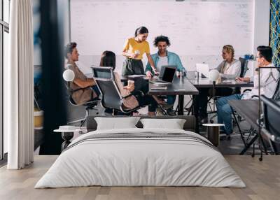 multiethnic business partners having meeting at table with laptops in modern office Wall mural