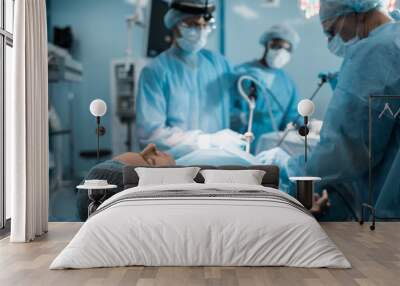 multiethnic surgeons operating patient in operating room Wall mural