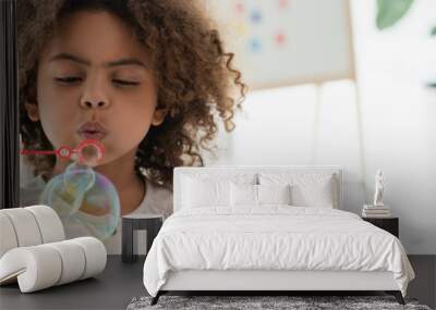 panoramic shot of curly african american kid blowing soap bubbles Wall mural