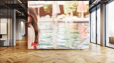 panoramic shot of happy young couple relaxing in swimming pool with glasses of refreshing drink Wall mural