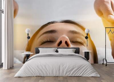 panoramic shot of healer standing near patient on massage table and cleaning aura Wall mural