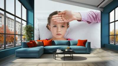 panoramic shot of mother touching forehead of ill daughter with fever Wall mural