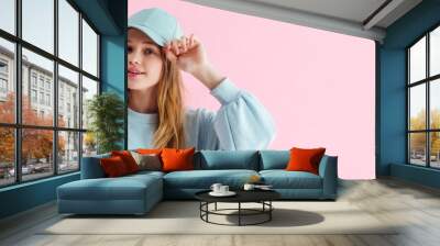 panoramic shot of pretty smiling teenage girl in cap isolated on pink Wall mural