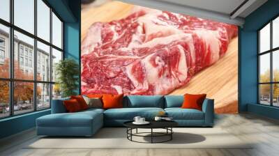 Panoramic shot of raw meat on wooden cutting board on marble surface near grape Wall mural