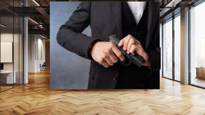 partial view of armed businessman in black suit on grey background with smoke Wall mural