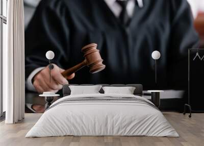 partial view of blurred judge in robe holding gavel in court Wall mural