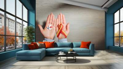 partial view of female doctor holding ribbon and pills, world hepatitis day concept Wall mural