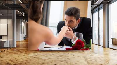 partial view of man kissing girlfirend hand on romantic date in restaurant, st valentine day Wall mural