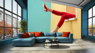 partial view of woman in red pants and shoes outstretching legs out decorative window Wall mural