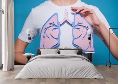 partial view of woman in white tshirt with paper crafted lungs on blue backdrop Wall mural