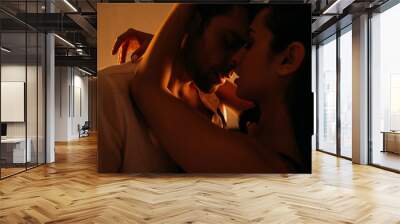 Passionate woman hugging businessman with closed eyes in bedroom Wall mural