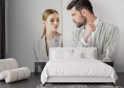 passionate young male and female models in vintage jackets looking at each other on white Wall mural