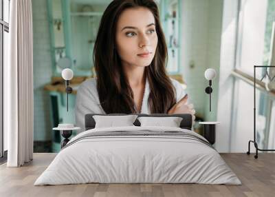 pensive brunette girl in bathrobe looking at window in bathroom Wall mural