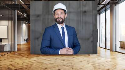 portrait of bearded middle aged businessman in hard hat smiling at camera Wall mural