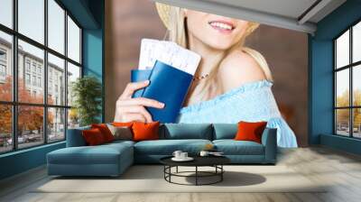 Portrait of beautiful young blonde woman in hat holding passports and tickets, getting ready to travel concept Wall mural