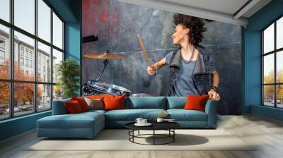 portrait of emotional woman playing drums in studio, drummer rock concept Wall mural