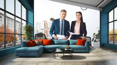 portrait of smiling business colleagues with papers at workplace in office Wall mural