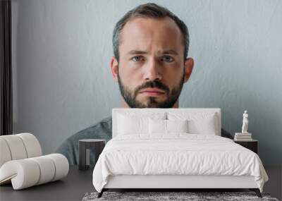 portrait of unhappy bearded man looking at camera on grey Wall mural