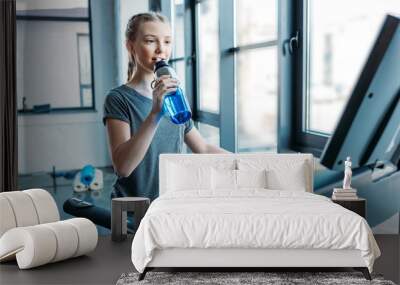 preteen girl training on treadmill and drinking water in fitness class. gym class kids concept Wall mural